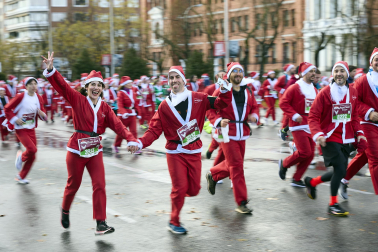 Participantes de todas las edades recorren el centro de Madrid vestidos de papá noeles durante la 14ª edición de la Carrera de Papá Noel, este domingo 21 de diciembre