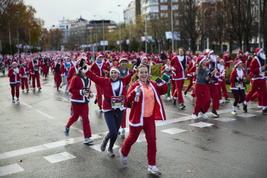 Participantes de todas las edades recorren el centro de Madrid vestidos de papá noeles durante la 14ª edición de la Carrera de Papá Noel, este domingo 21 de diciembre