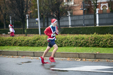 Participantes de todas las edades recorren el centro de Madrid vestidos de papá noeles durante la 14ª edición de la Carrera de Papá Noel, este domingo 21 de diciembre