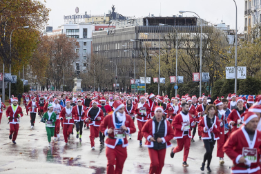 Participantes de todas las edades recorren el centro de Madrid vestidos de papá noeles durante la 14ª edición de la Carrera de Papá Noel, este domingo 21 de diciembre