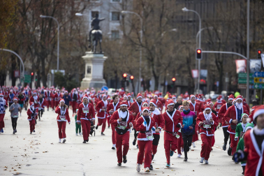 Participantes de todas las edades recorren el centro de Madrid vestidos de papá noeles durante la 14ª edición de la Carrera de Papá Noel, este domingo 21 de diciembre