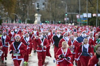Participantes de todas las edades recorren el centro de Madrid vestidos de papá noeles durante la 14ª edición de la Carrera de Papá Noel, este domingo 21 de diciembre