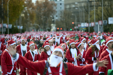 Participantes de todas las edades recorren el centro de Madrid vestidos de papá noeles durante la 14ª edición de la Carrera de Papá Noel, este domingo 21 de diciembre