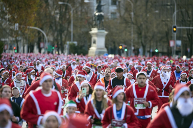 Participantes de todas las edades recorren el centro de Madrid vestidos de papá noeles durante la 14ª edición de la Carrera de Papá Noel, este domingo 21 de diciembre