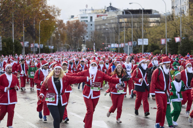 Participantes de todas las edades recorren el centro de Madrid vestidos de papá noeles durante la 14ª edición de la Carrera de Papá Noel, este domingo 21 de diciembre