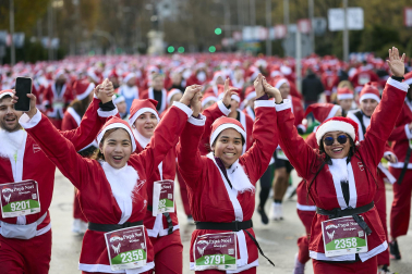Participantes de todas las edades recorren el centro de Madrid vestidos de papá noeles durante la 14ª edición de la Carrera de Papá Noel, este domingo 21 de diciembre