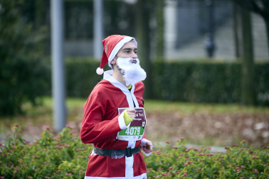 Participantes de todas las edades recorren el centro de Madrid vestidos de papá noeles durante la 14ª edición de la Carrera de Papá Noel, este domingo 21 de diciembre