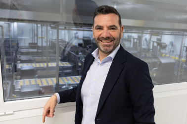 Sergio Beni, en la planta de Funes. Al fondo, proceso de elaboración de tortillas