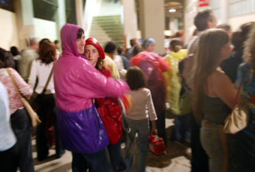 Una pareja con chubasqueros se protege de la lluvia en los pasillos de la plaza