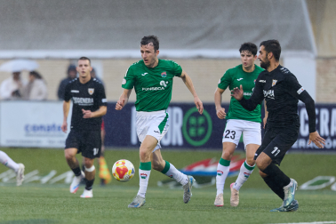 Unai Martínez 'Budi', del San Juan, conduce el balón ante Mikel Santamaría, defensa del Izarra