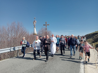 La efigie del Ángel de Aralar y la cruz del santuario nada más iniciar el camino. Tras ellas, el capellán, Alfonso Garciandía.