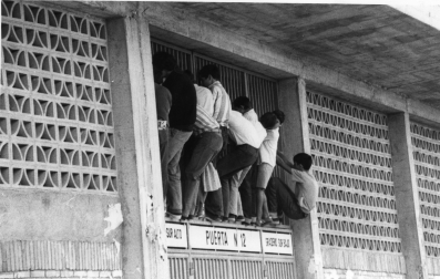 Unos aficionados intentando ver el partido desde la calle