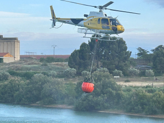 El helicóptero toma agua para sofocar las llamas