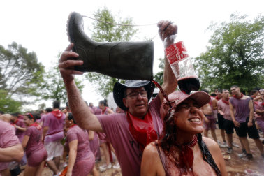 HARO (ESPAÑA), 29/06/2026.- Un grupo de personas participa este lunes en la batalla del Vino de Haro, Fiesta de Interés Turístico Nacional, en la que sus participantes se lanzan unos a otros litros de vino sin descanso en un impresionante espectáculo, que concluye al mediodía, y que en 2025, al ser domingo, congregó a cerca de 10.000 personas, que tiñeron de morado el paraje de los Riscos de Bilibio con unos 40.000 litros de vino. EFE/ Villar López