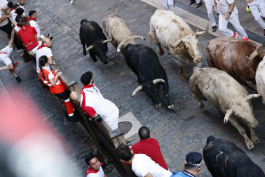 Fotos del primer encierro de San Fermín a su paso por la plaza del Ayuntamiento.