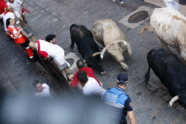 Fotos del primer encierro de San Fermín a su paso por la plaza del Ayuntamiento.