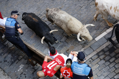Fotos del primer encierro de San Fermín a su paso por la plaza del Ayuntamiento.