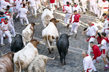 Fotos del primer encierro de San Fermín a su paso por la plaza del Ayuntamiento.