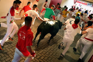 Primer encierro de San Fermín 2026 en el tramo del callejón de entrada a la plaza de toros.