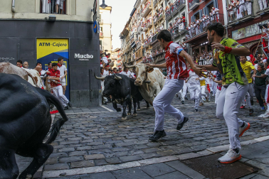 Segundo encierro de San Fermín 2026 con toros de Cebada Gago en la curva de Mercaderes.