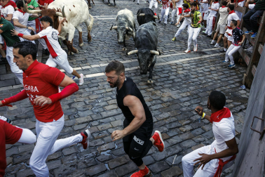 Segundo encierro de San Fermín 2026 con toros de Cebada Gago en la curva de Mercaderes.