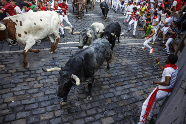 Segundo encierro de San Fermín 2026 con toros de Cebada Gago en la curva de Mercaderes.