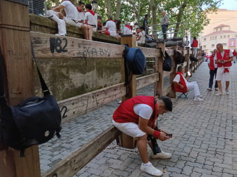 Bolsos y mochilas para guardar el sitio antes del sexto encierro en Pamplona