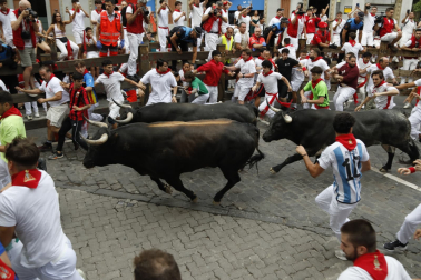 Séptimo encierro de San Fermín con toros de Miura en la curva de Telefónica.