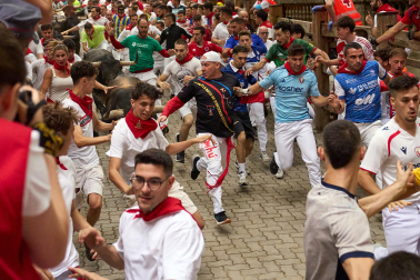 Fotos del séptimo encierro de San Fermín 2026 con toros de Miura en la bajada al callejón.