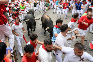 Fotos del séptimo encierro de San Fermín 2026 con toros de Miura en la curva de Telefónica.