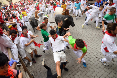 Fotos del séptimo encierro de San Fermín 2026 con toros de Miura en la curva de Telefónica.