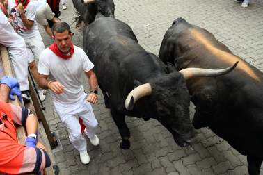 Fotos del séptimo encierro de San Fermín 2026 con toros de Miura en la curva de Telefónica.