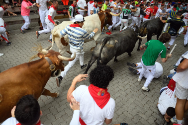 Fotos del séptimo encierro de San Fermín 2026 con toros de Miura en la curva de Telefónica.