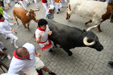 Fotos del séptimo encierro de San Fermín 2026 con toros de Miura en la curva de Telefónica.