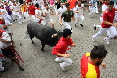 Fotos del séptimo encierro de San Fermín 2026 con toros de Miura en la curva de Telefónica.
