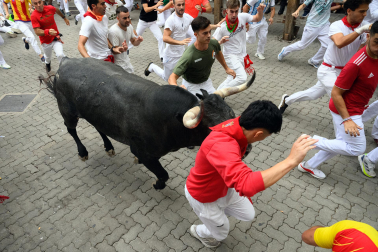Fotos del séptimo encierro de San Fermín 2026 con toros de Miura en la curva de Telefónica.