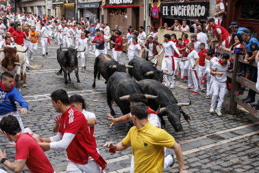 Fotos del séptimo encierro de San Fermín 2026 con toros de Miura en la curva de Mercaderes.