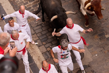 Fotos del séptimo encierro de San Fermín 2026 con toros de Miura en la cuesta de Santo Domingo.