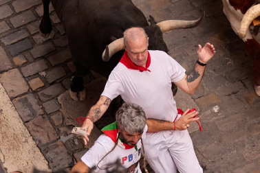 Fotos del séptimo encierro de San Fermín 2026 con toros de Miura en la cuesta de Santo Domingo.
