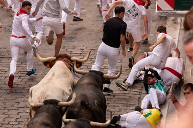 Fotos del séptimo encierro de San Fermín 2026 con toros de Miura en la cuesta de Santo Domingo.