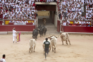 Fotos del séptimo encierro de San Fermín 2026 con toros de Miura en el callejón y plaza de toros.
