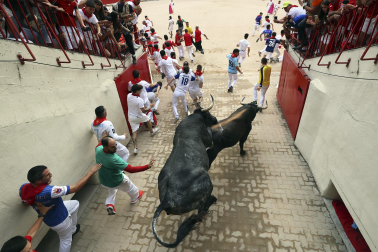 Fotos del séptimo encierro de San Fermín 2026 con toros de Miura en el callejón y plaza de toros.