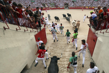 Fotos del séptimo encierro de San Fermín 2026 con toros de Miura en el callejón y plaza de toros.