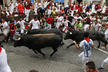 Fotos del séptimo encierro de San Fermín 2026 con toros de Miura en la curva de Telefónica.