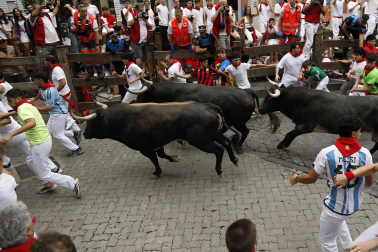 Fotos del séptimo encierro de San Fermín 2026 con toros de Miura en la curva de Telefónica.