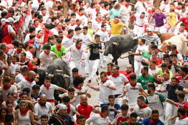 Fotos del séptimo encierro de San Fermín 2026 con toros de Miura en la bajada al callejón.