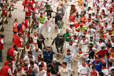 Fotos del séptimo encierro de San Fermín 2026 con toros de Miura en la bajada al callejón.