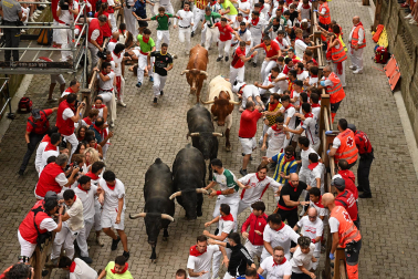 Fotos del séptimo encierro de San Fermín 2026 con toros de Miura en la bajada al callejón.