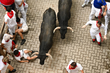 Fotos del séptimo encierro de San Fermín 2026 con toros de Miura en la bajada al callejón.