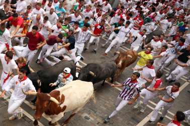 Fotos del séptimo encierro de San Fermín 2026 con toros de Miura en la calle Estafeta.